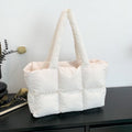 Soft Puffer Tote Bag in cream with long shoulder straps on black wood surface