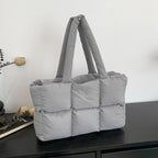 Soft Puffer Tote Bag in light gray with padded compartments on dark wood surface