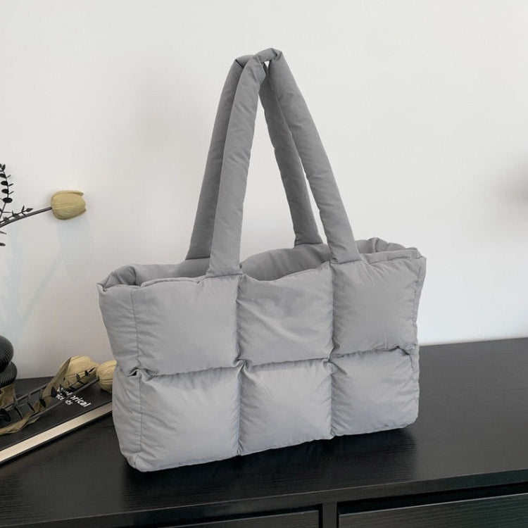 Soft Puffer Tote Bag in light gray with padded compartments on dark wood surface