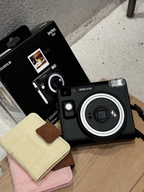 Toast Polaroid Memory Album mini photo albums in cream and pink beside a Fujifilm Instax Mini camera