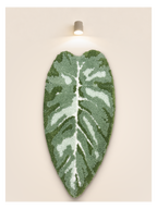 Tufted Plant Rug - leaf-shaped tufted wall hanging in sage green, mounted on beige wall
