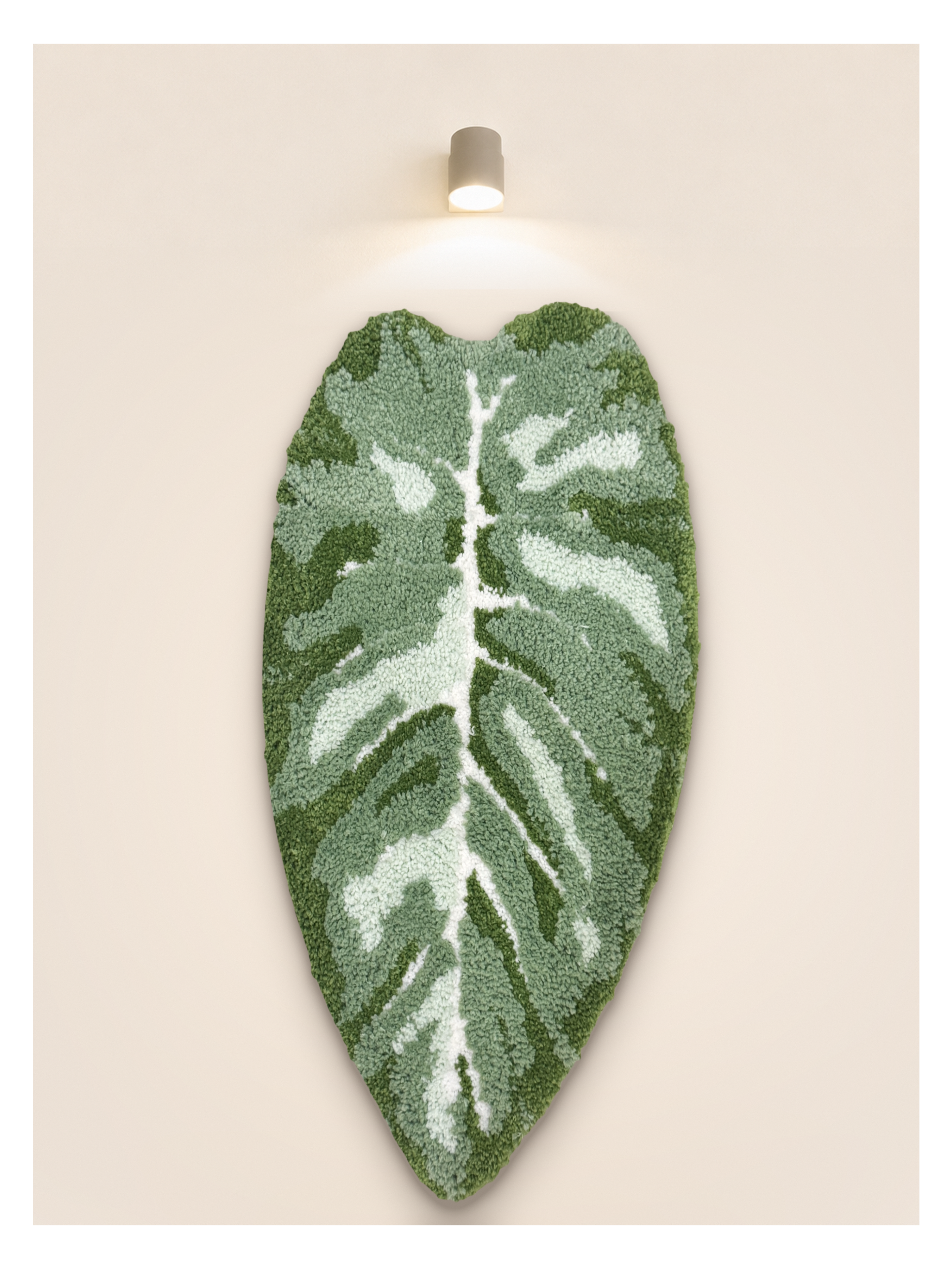 Tufted Plant Rug - leaf-shaped tufted wall hanging in sage green, mounted on beige wall