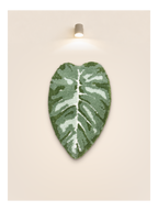 Tufted Plant Rug - full view of leaf-shaped tufted rug in green and white on beige wall