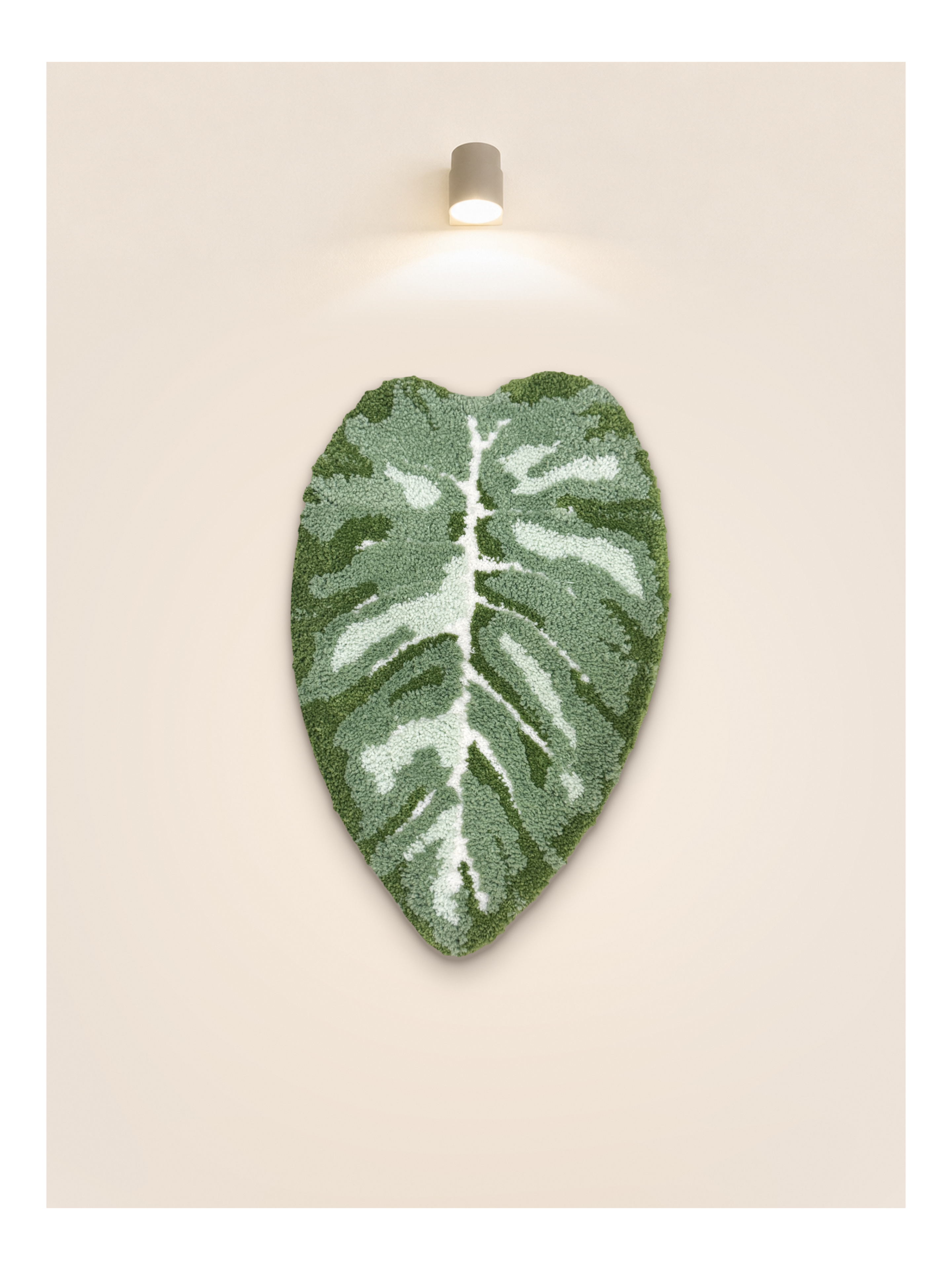Tufted Plant Rug - full view of leaf-shaped tufted rug in green and white on beige wall