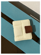 Toast Polaroid Memory Album - cream quilted mini photo album with brown leather tab closure on blue wood surface
