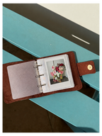 Toast Polaroid Memory Album shown open on a turquoise surface with a sample instant photo inside