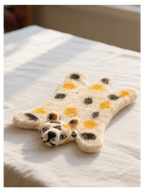 Wool Felt Animal Coaster - leopard-shaped felt coaster in cream and gold, flat view on white blanket