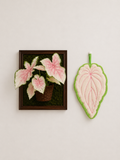 Caladium Leaf Hand Towel - pale pink and green leaf-shaped hand towel beside framed caladium plant art